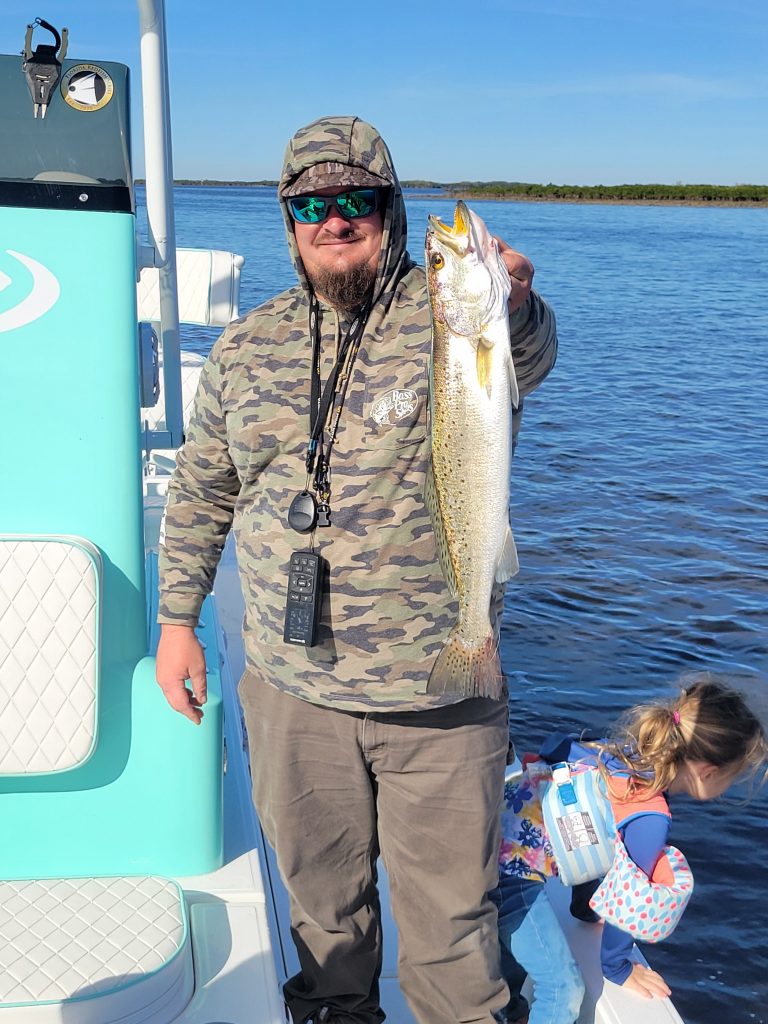 Man holds up a fish during an Inshore Fishing Charter in Weeki Wachee FL